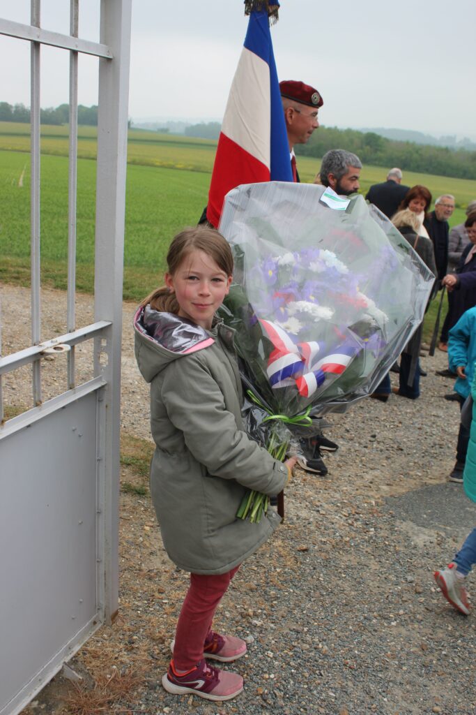Une jeune fille avec un bouquet de fleur lors de la commémoration du 8 mai