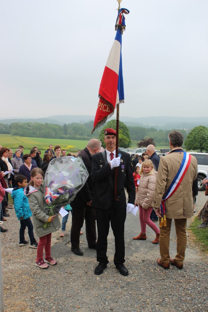 Un porte-drapeau à côté d'une jeune fille avec un bouquet de fleur